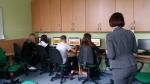 Młodzież przy komputerach podczas szkolenia z pracownikiem urzędu skarbowego. 
