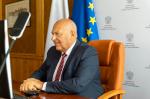 Przy biurku siedzi uśmiechnięty Minister finansów, funduszy i polityki regionalnej Tadeusz Kościński