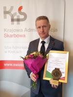 Dyrektor IAS w Kielcach Sławomir Podkówka z nagrodami - dyplom, statuetka, kwiaty