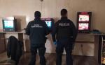 W pokoju znajdują się trzy automaty do gier hazardowych, przy których stoją dwaj funkcjonariusze: Policji i Świętokrzyskiego Urzędu Celno-Skarbowego.